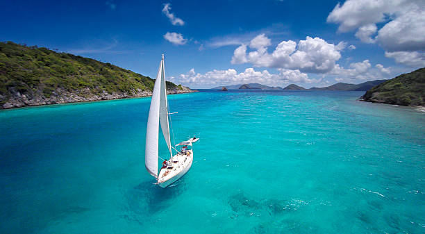 aerial view of a sloop sailing through the Caribbean aerial view of a sloop under full sails sailing through the Caribbean st. thomas virgin islands photos stock pictures, royalty-free photos & images