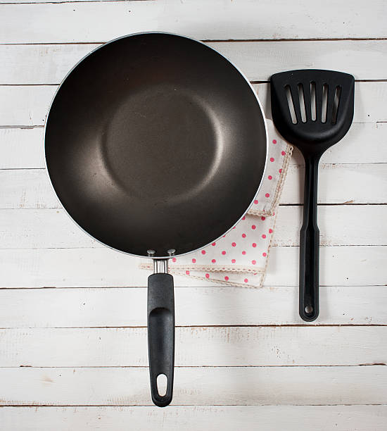 istock Empty cooking frying pan with turner on wooden background 468106910