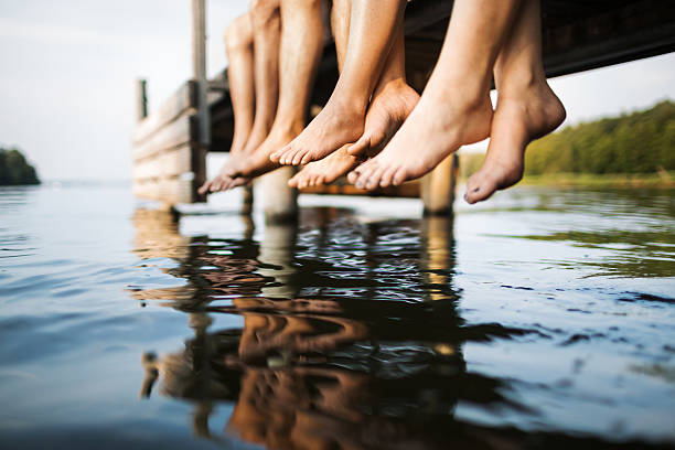 deux couples assis sur un ponton - ponton photos et images de collection