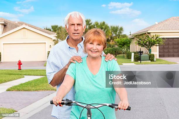 Senior Couple With Bicycle In Residential Neighborhood Stock Photo - Download Image Now