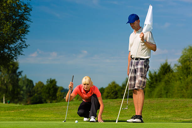 istock Young sportive couple playing golf on a course 468115645