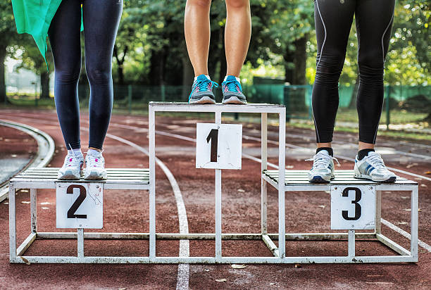 Athlets on Podium 3 Athlets on Podium at the end of the race, athletics track on the background. medallist stock pictures, royalty-free photos & images