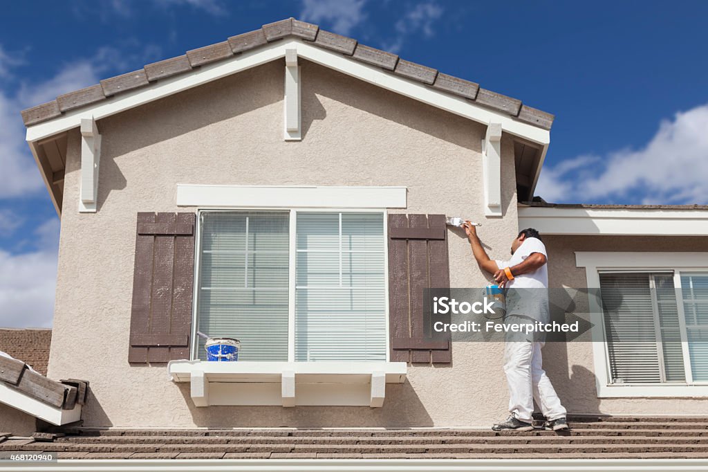 House Painter Painting the Trim And Shutters of Home Busy House Painter Painting the Trim And Shutters of A Home. House Stock Photo