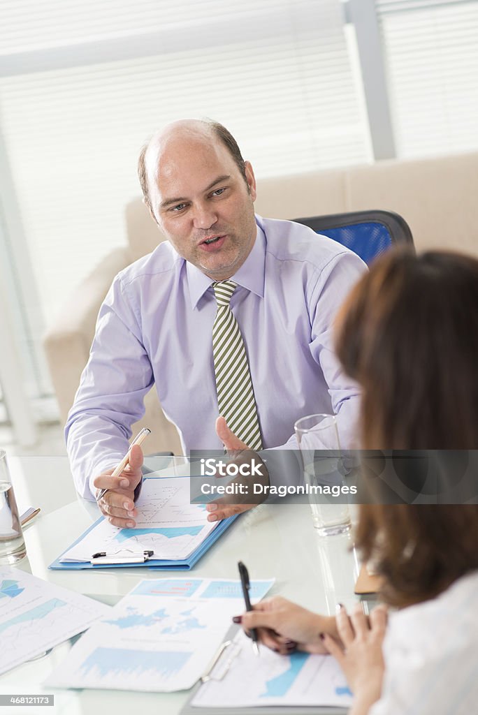 Emotional boss Vertical image of an emotional boss explaining something to his colleague at the office on the foreground Adult Stock Photo