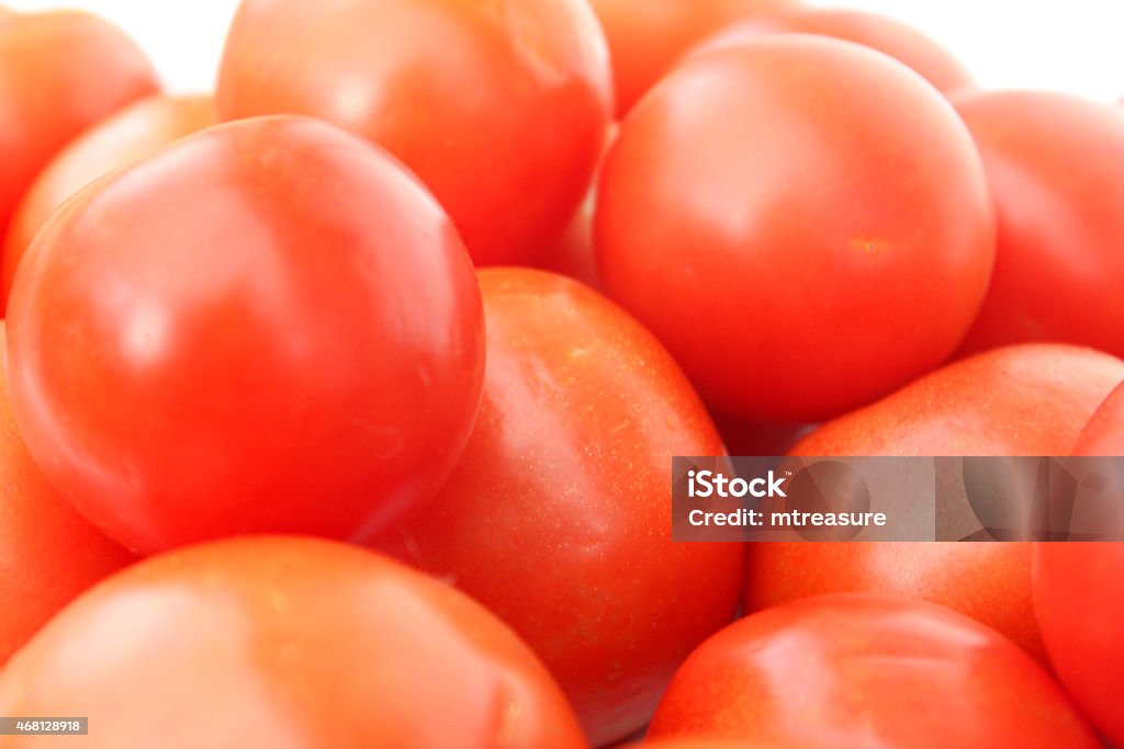 Image of fresh, red salad tomatoes in pile, healthy eating Photo showing some large red salad tomatoes in a pile.  These fresh vegetables are considered to be a fruit, being eaten raw and cooked in soups, ragu pasta sauces and stews.  There are many health benefits associated with eating tomatoes, since they  are rich in antioxidants and nutrients. 2015 Stock Photo