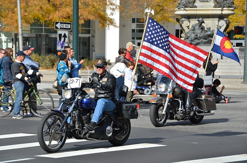 Denver, СO, USA - November 9, 2013: Veterans riding their motocycles in the Denver Veteran's day Parade. This Veteran put a huge American flag on the back of his bike to show his love for his country. 
