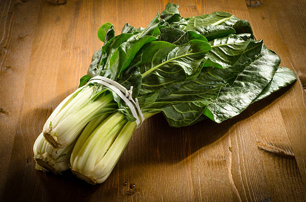 Bunch of fresh chard laying on wooden board stock photo