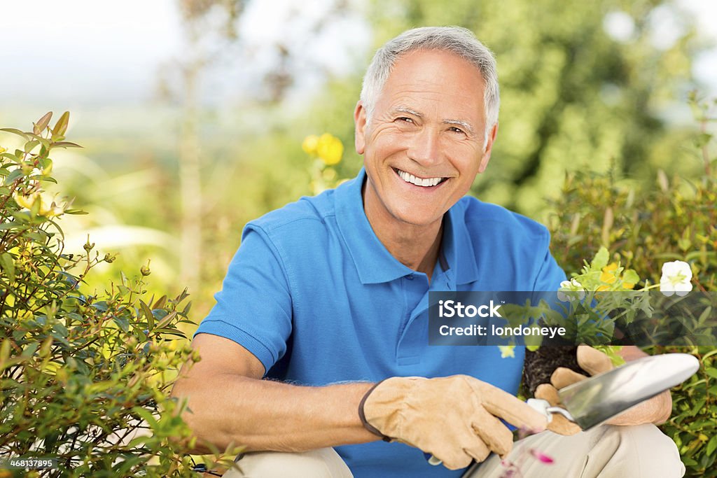 Alter Mann hält eine Kelle-Handwerk und Garten und Schössling im Garten. - Lizenzfrei 60-69 Jahre Stock-Foto