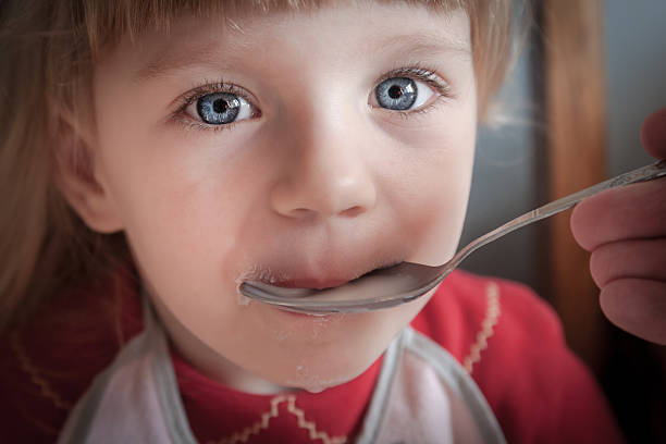 istock Baby girl being fed by hand. 468138607