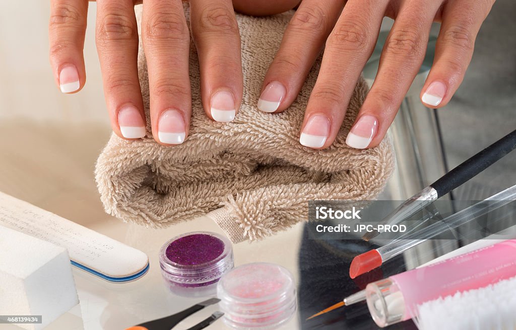 Hands of young woman with french manicure on the towel 2015 Stock Photo