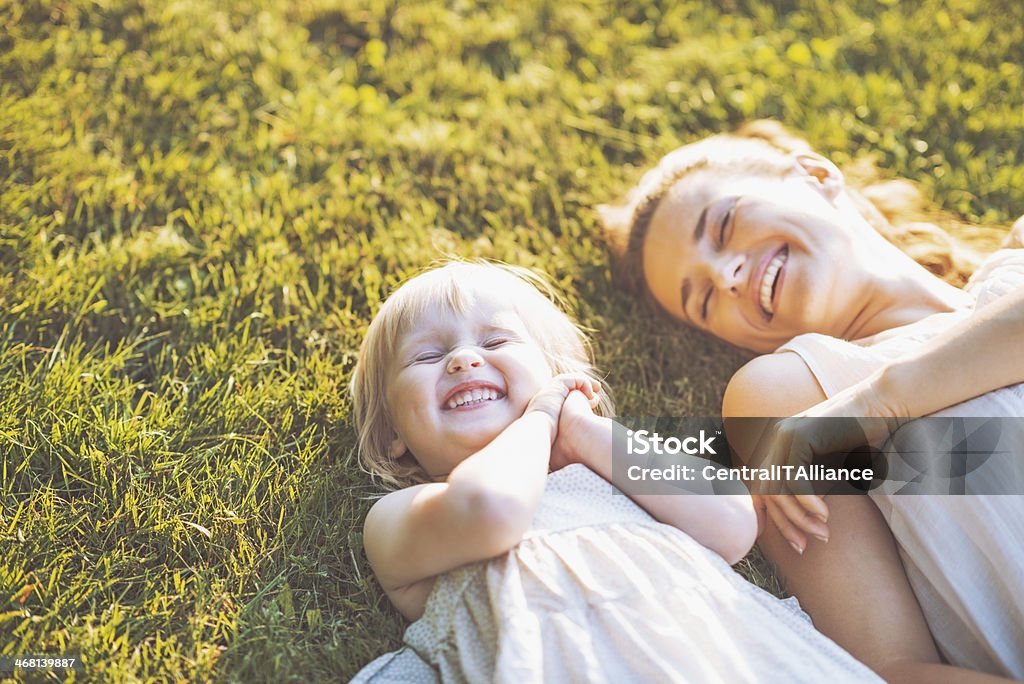 Lächelnd Mutter und baby Leg dich auf Wiese - Lizenzfrei Mutter Stock-Foto