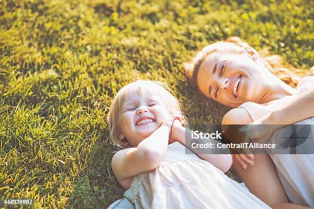 Smiling Mother And Baby Laying On Meadow Stock Photo - Download Image Now - Mother, Family, Child