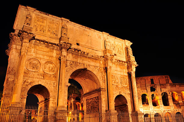 view of the Arch of Constantine and the Coliseum at night in Rome, Italy