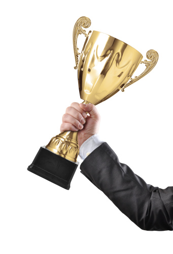 Golden winners cup in man's hands on white background isolated, copy space, space for text