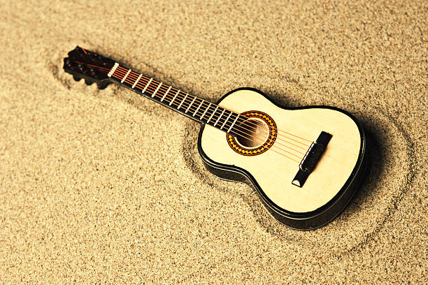 istock spanish guitar in the sand 468144718
