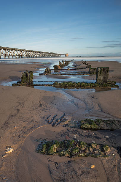 Old Pier Small Stream on a Sandy Beach with an Old Pier hartlepool photos stock pictures, royalty-free photos & images
