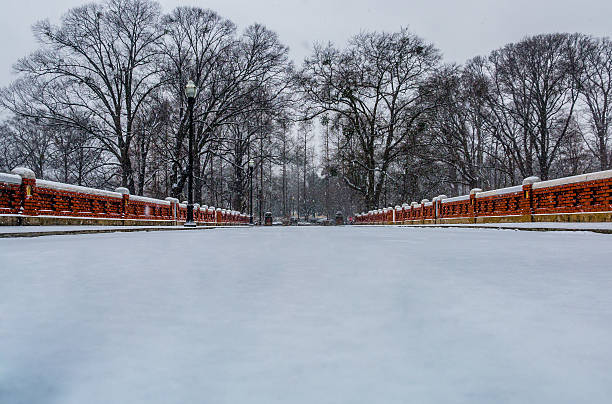 The Park Drive entrance to Piedmont Park in midtown Atlanta GA, with snowfall on the ground and barren, winter trees in the background.