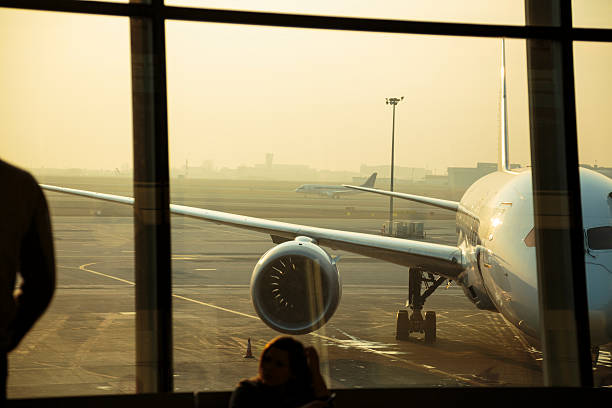 avion de passagers à travers la fenêtre de l'aéroport de varsovie - airport window outdoors airfield photos et images de collection