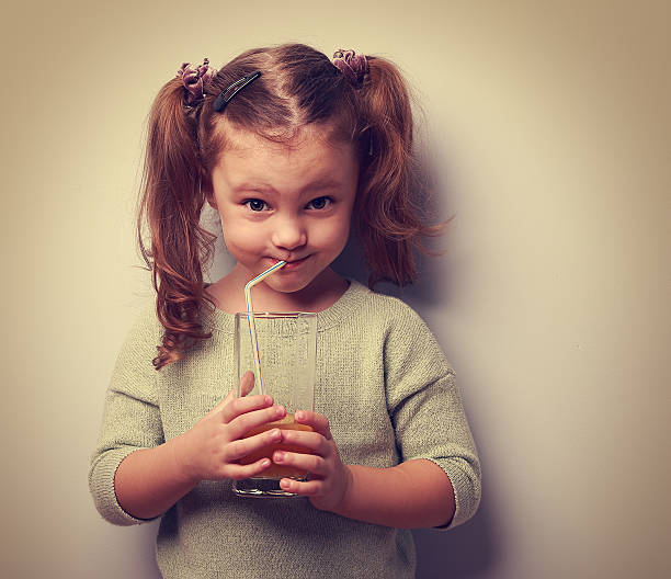 istock Happy kid drinking juice from glass and looking humor 468149096