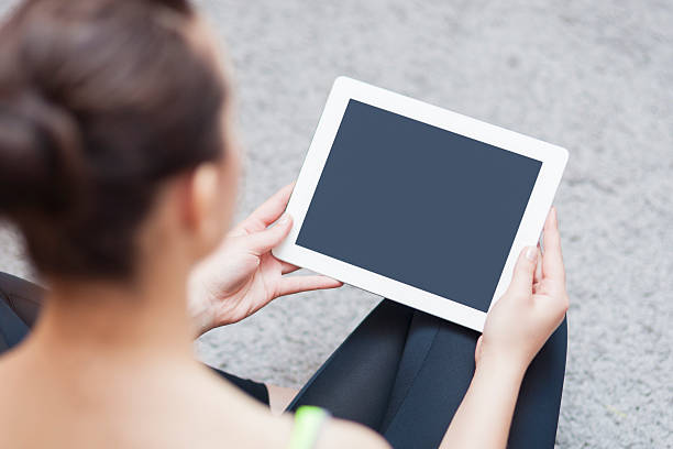 istock Back View Portrait of Woman Holding Tablet Computer. Focus on Tablet Computer 468150478