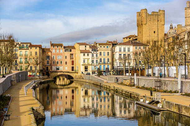 Reflection of buildings in the Canal de la Robine in France stock photo