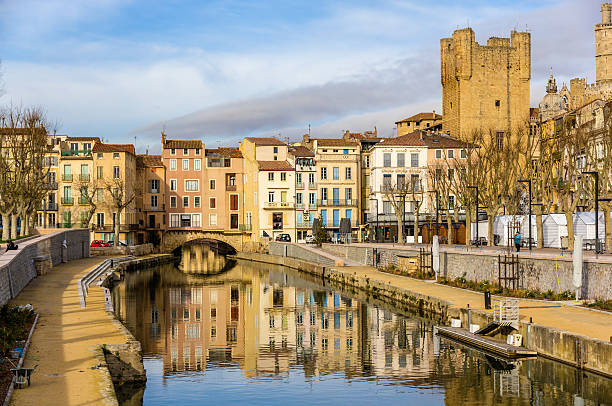 Reflection of buildings in the Canal de la Robine in France Canal de la Robine in Narbonne, Languedoc-Roussillon - France narbonne stock pictures, royalty-free photos & images