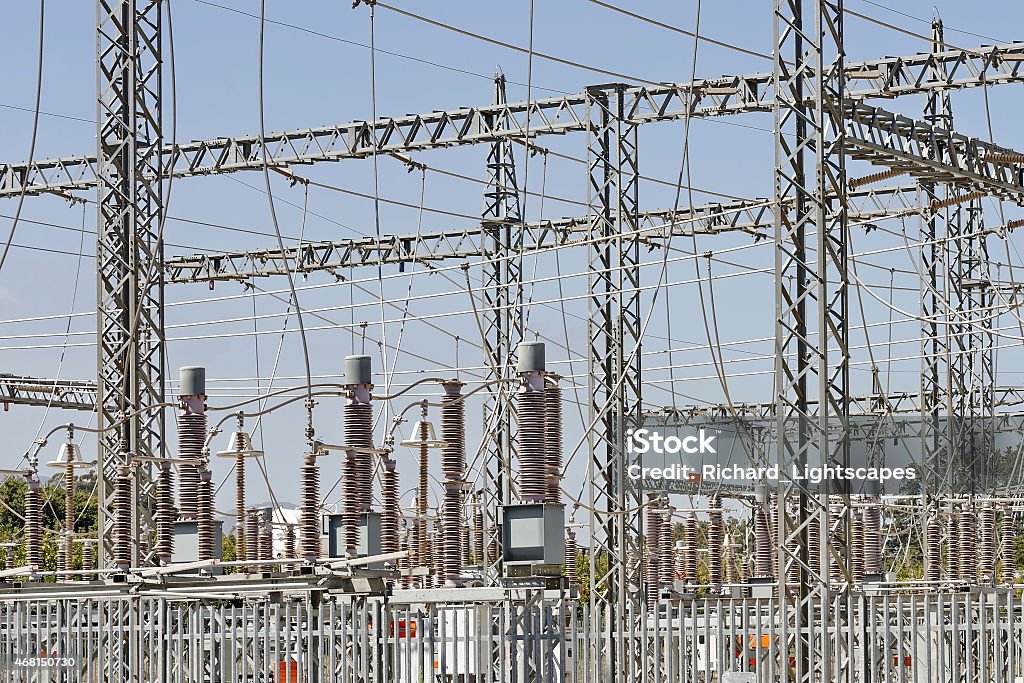 Electrical power substation Detail image of an electrical substation with transformer equipment set against a clear blue sky 2015 Stock Photo