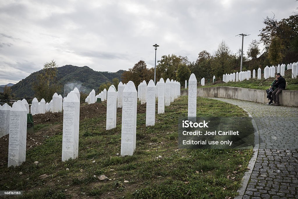 Coppia abbracciare nel cimitero di Srebrenica - Foto stock royalty-free di Abbracciare una persona
