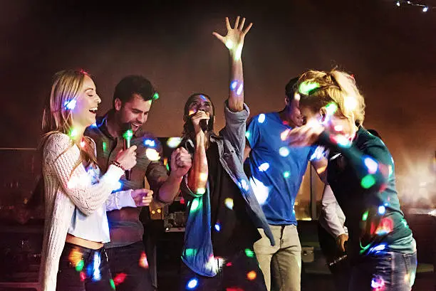 Photo of Group of friends doing karaoke