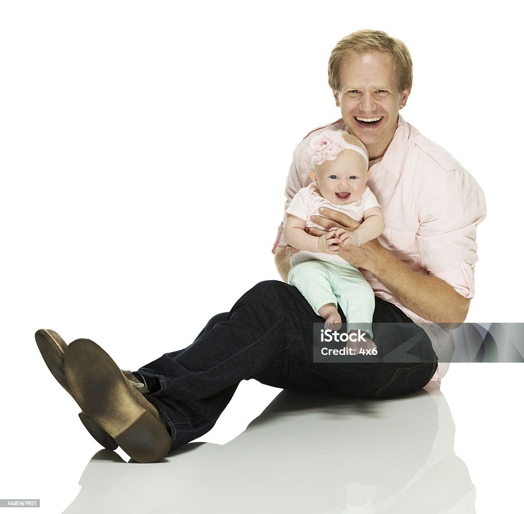 Smiling father sitting on floor with his baby Smiling father sitting on floor with his babyhttp://www.twodozendesign.info/i/1.png Baby - Human Age Stock Photo