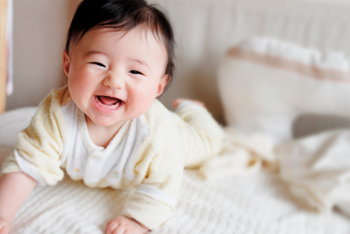 Baby laughing on bed