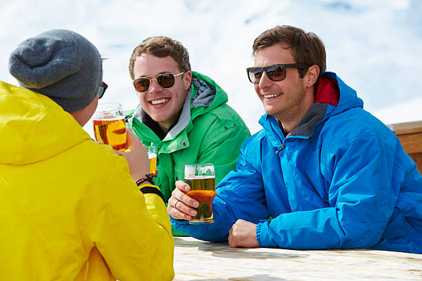 grupo de jovens aproveita bebida no resort de esqui - apres ski ski restaurant mountain - fotografias e filmes do acervo