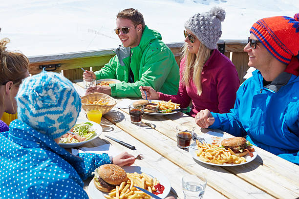 grupo de amigos disfrutando de una comida en la cafetería en el complejo turístico de esquí - apres ski friendship skiing enjoyment fotografías e imágenes de stock