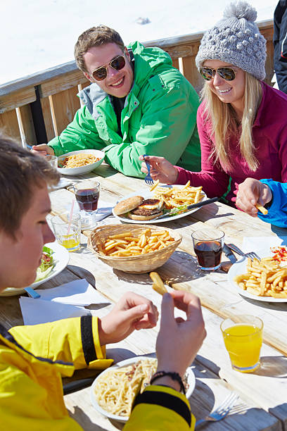 grupo de amigos disfrutando de una comida en la cafetería en el complejo turístico de esquí - apres ski ski restaurant mountain fotografías e imágenes de stock