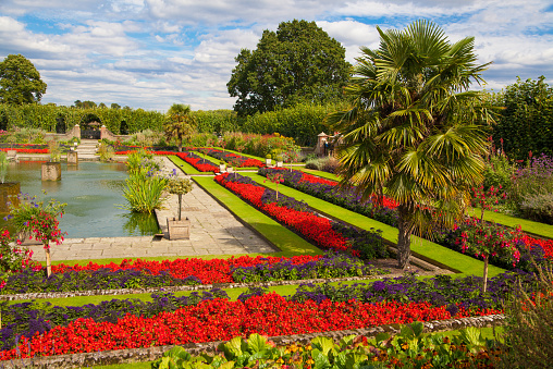 London, UK - August 16, 2014: Kensington garden, fountain and flower beds in front of Kensington palace