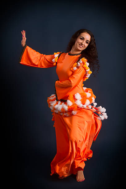 istock dancer posing in traditional orange costume 468168035