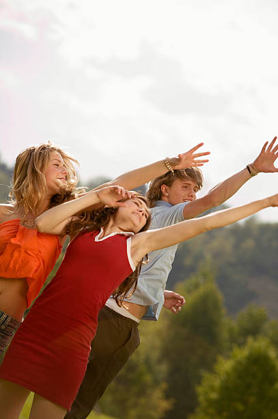 istock Young people in meadow, arms up 468168684