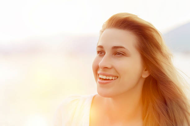 Attractive young woman daydreaming and looking through the window