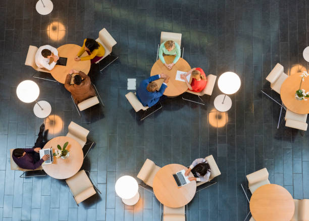 istock Business people sitting at tables in office lobby 468170196