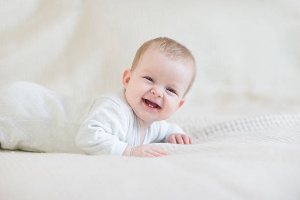 sonriente bebé en la cama - baby cute laughing human face fotografías e imágenes de stock