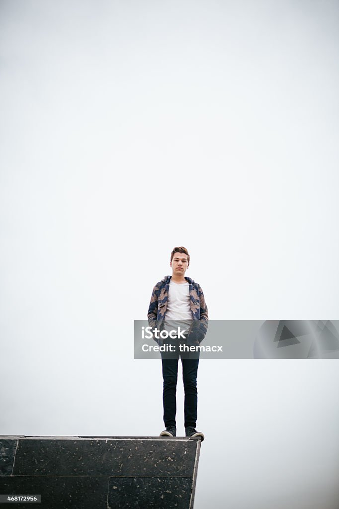 Young man standing on stone block Young man standing on stone block. 20-24 Years Stock Photo