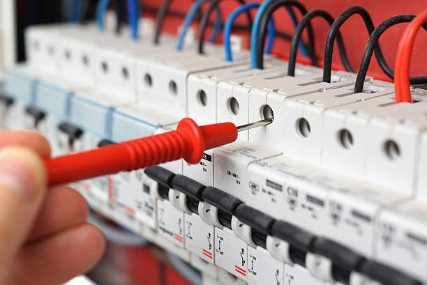 Hand of electrician with multimeter probe at electrical switchgear cabinet Hand of an electrician with multimeter probe at an electrical switchgear cabinet maintenance engineer fuel and power generation power line electricity stock pictures, royalty-free photos & images