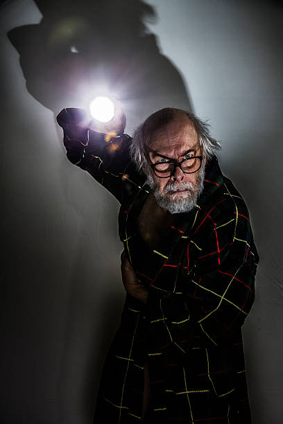 istock Suspicious Senior Man Pointing Flashlight in Dark Spooky Room 468173144