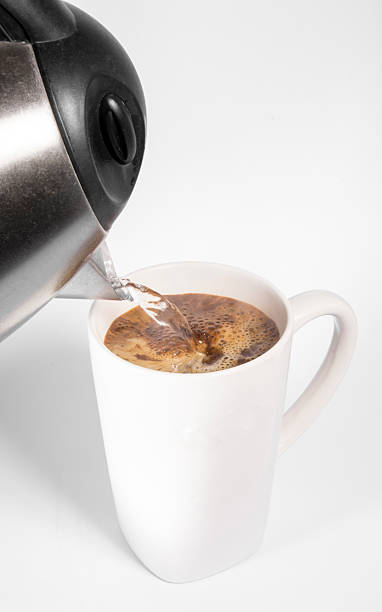 istock Pouring hot water from kettle into mug of coffee 468173501