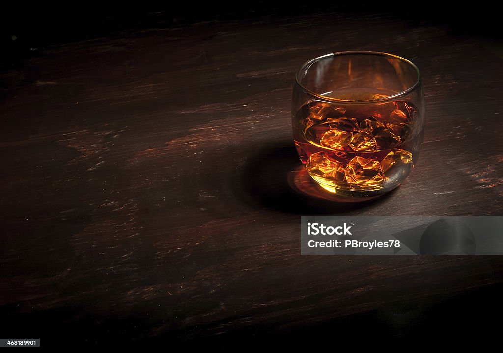 Whiskey on Dark Wood Bar Glass of whiskey on a dark wood bar. Alcohol - Drink Stock Photo