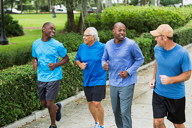 istock Four multiracial men jogging in park 468190968