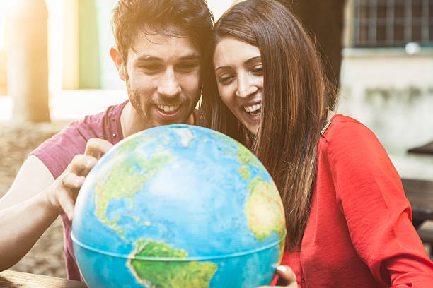 istock Young couple laughing and looking at a globe 468191464