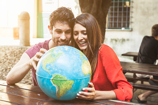 istock Young couple looks the world map 468191466