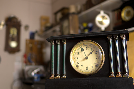 An old antique mantle clock built in 1922 showing the time approaching 2:00. The clock was built by the Sessions Clock Company of Forestville Connecticut.