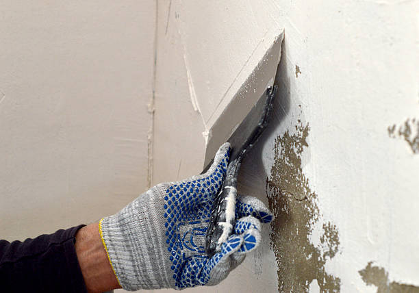 istock process of applying a white putty on concrete gray wall 468199970
